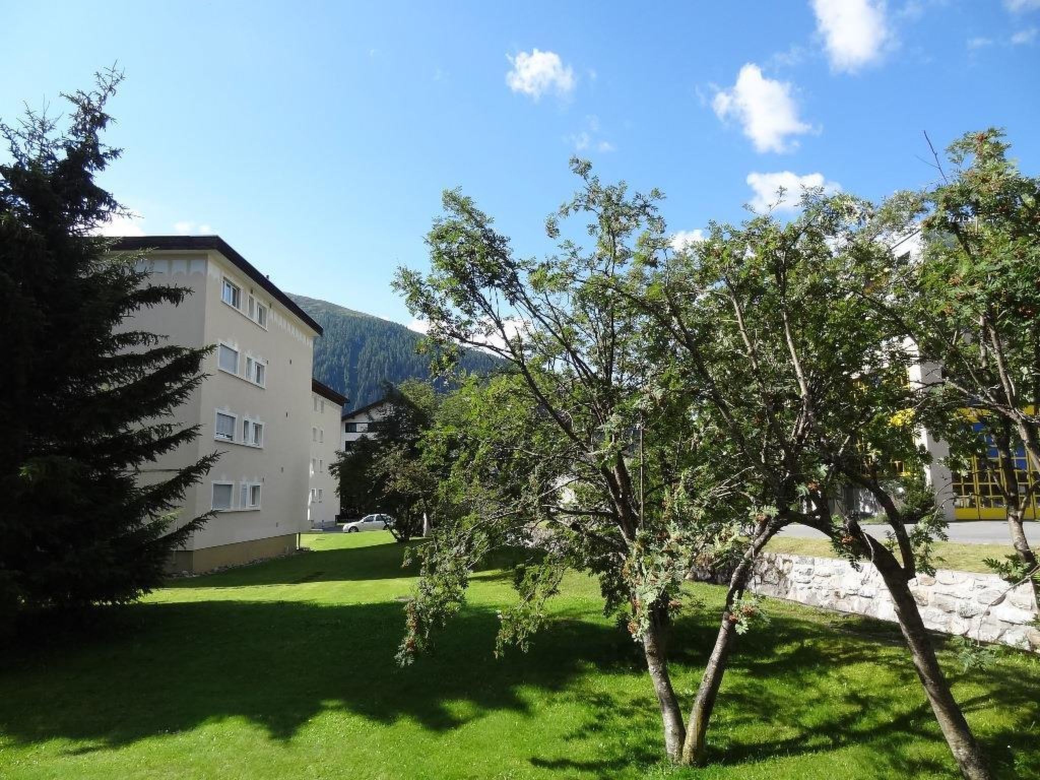 A building with multiple windows and a grassy area in front.