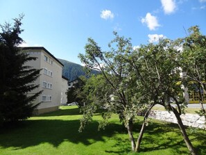 A building with multiple windows and a grassy area in front. - Chesa Plonta Appartement/Fewo, Dusche oder Bad, WC 3½-Zimmerwohnung by Interhome (Davos)