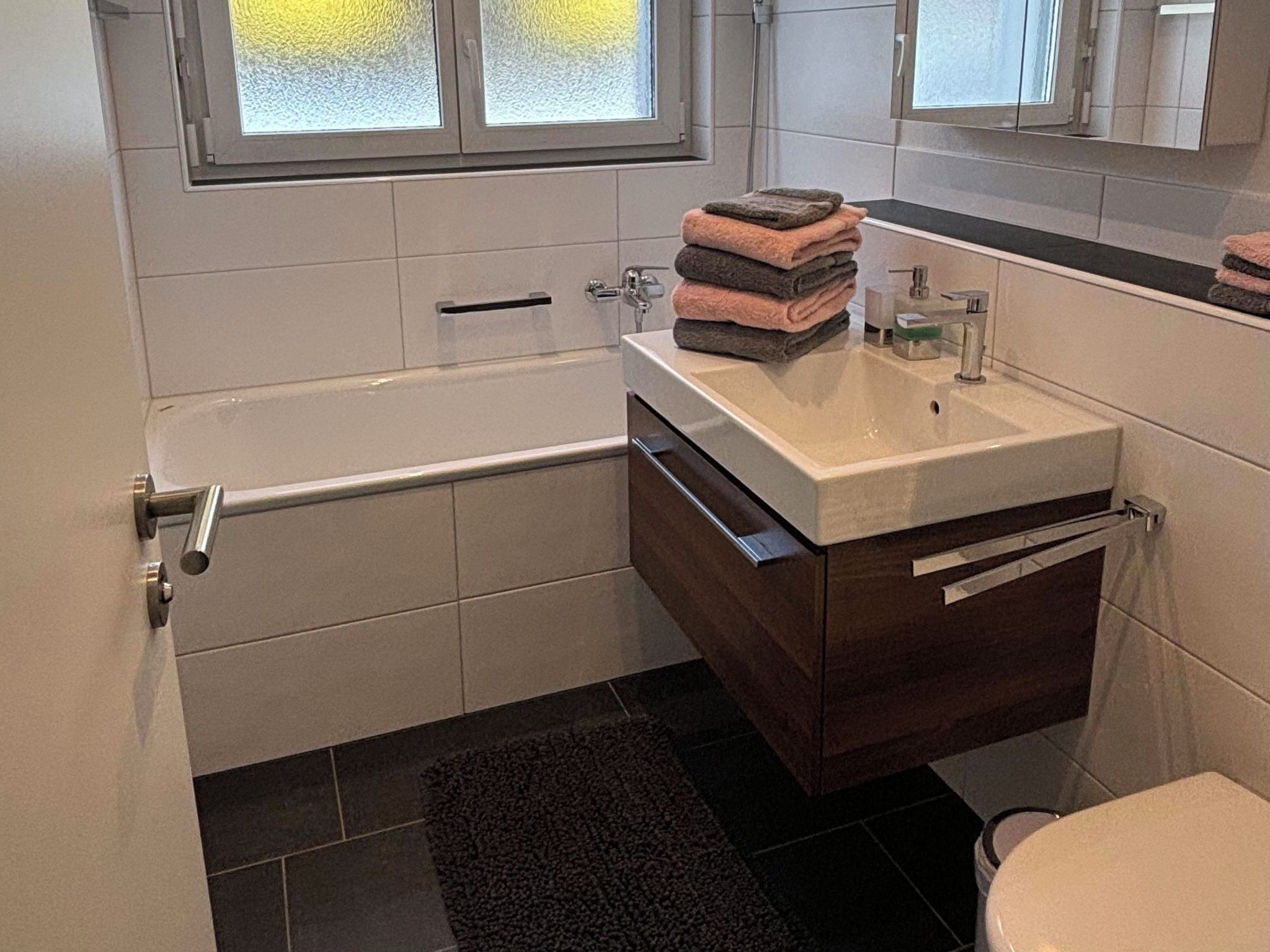 Een badkamer met een bad, wastafel en toilet.