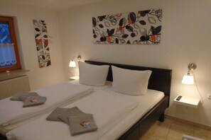 Ein Hotelzimmer mit einem großen Bett, zwei Nachttischlampen und Bildern an den Wänden.