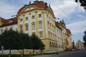 Ein historisches Gebäude mit klassischer Architektur, das eine geschwungene Fassade und zahlreiche Fenster aufweist.