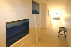 A narrow hallway with a bunk bed on the left and a small table on the right. - Apartment in Cadzand with swimming pool (Cadzand)