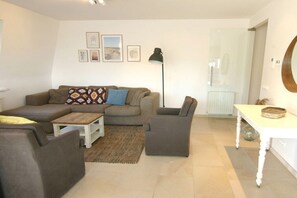 A living room with a sofa set, a coffee table, a floor lamp, and a dining table with a basket. - Apartment in Cadzand with swimming pool (Cadzand)