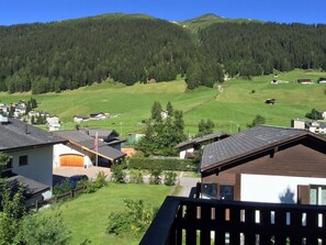 A residential area with houses, a green field, and a forested hill in the background. - Casa Berger Appartement/Fewo, Dusche oder Bad, WC 3½-Zimmerwohnung by Interhome (Davos)