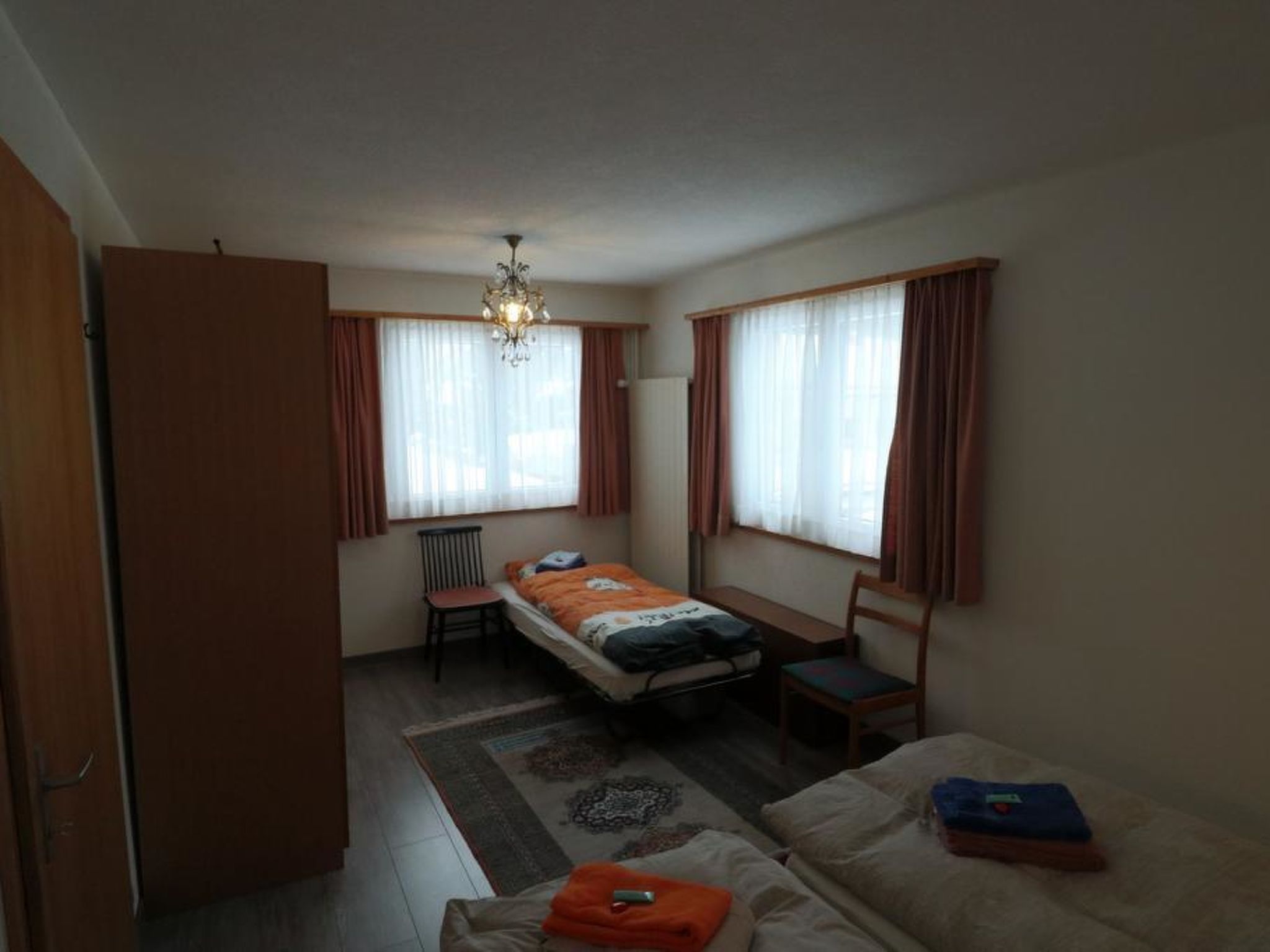 A compact room with a bed, a desk, a chair, and a sofa.