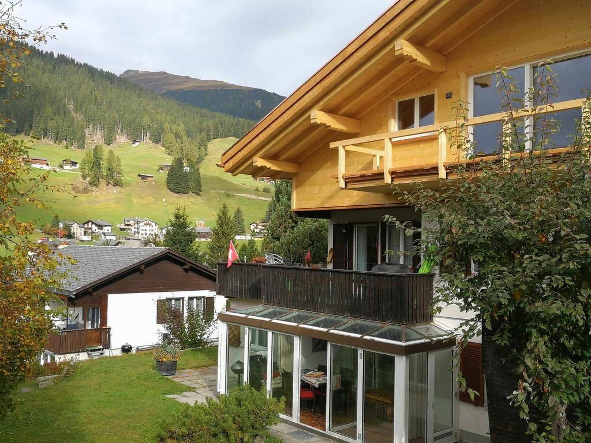 A two-story house with a balcony overlooking a valley.