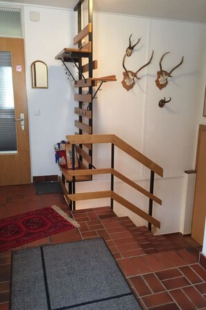 A staircase with wooden railings and a red patterned rug at the bottom. - Casa Berger Appartement/Fewo, Dusche oder Bad, WC 3½-Zimmerwohnung by Interhome (Davos)