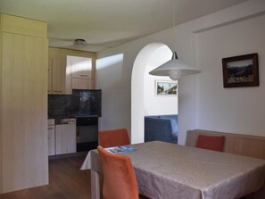 A compact living space with a kitchenette, a dining area, and a seating area with a view. - Sunna Büel Appartement/Fewo, Dusche oder Bad, WC 2½-Zimmerwohnung by Interhome (Davos)