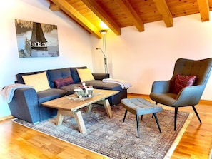A cozy living room with a sofa, a chair, a coffee table, and a floor lamp. - Sunni 2 Appartement/Fewo, Dusche oder Bad, WC 3-Zimmerwohnung by Interhome (Davos)