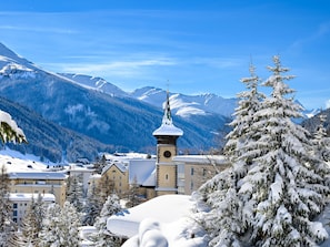 A snow-covered mountain town with a prominent church tower, surrounded by snow-laden trees and buildings. - Barga GP Appartement/Fewo, Dusche oder Bad, WC 2-Zimmerwohnung by Interhome (Davos)