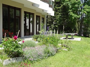 A modern building with large windows and a well-maintained garden with various plants and flowers. - Residenz im Park Whg Alpenblick Appartement/Fewo, Dusche oder Bad, WC by Interhome (Davos)