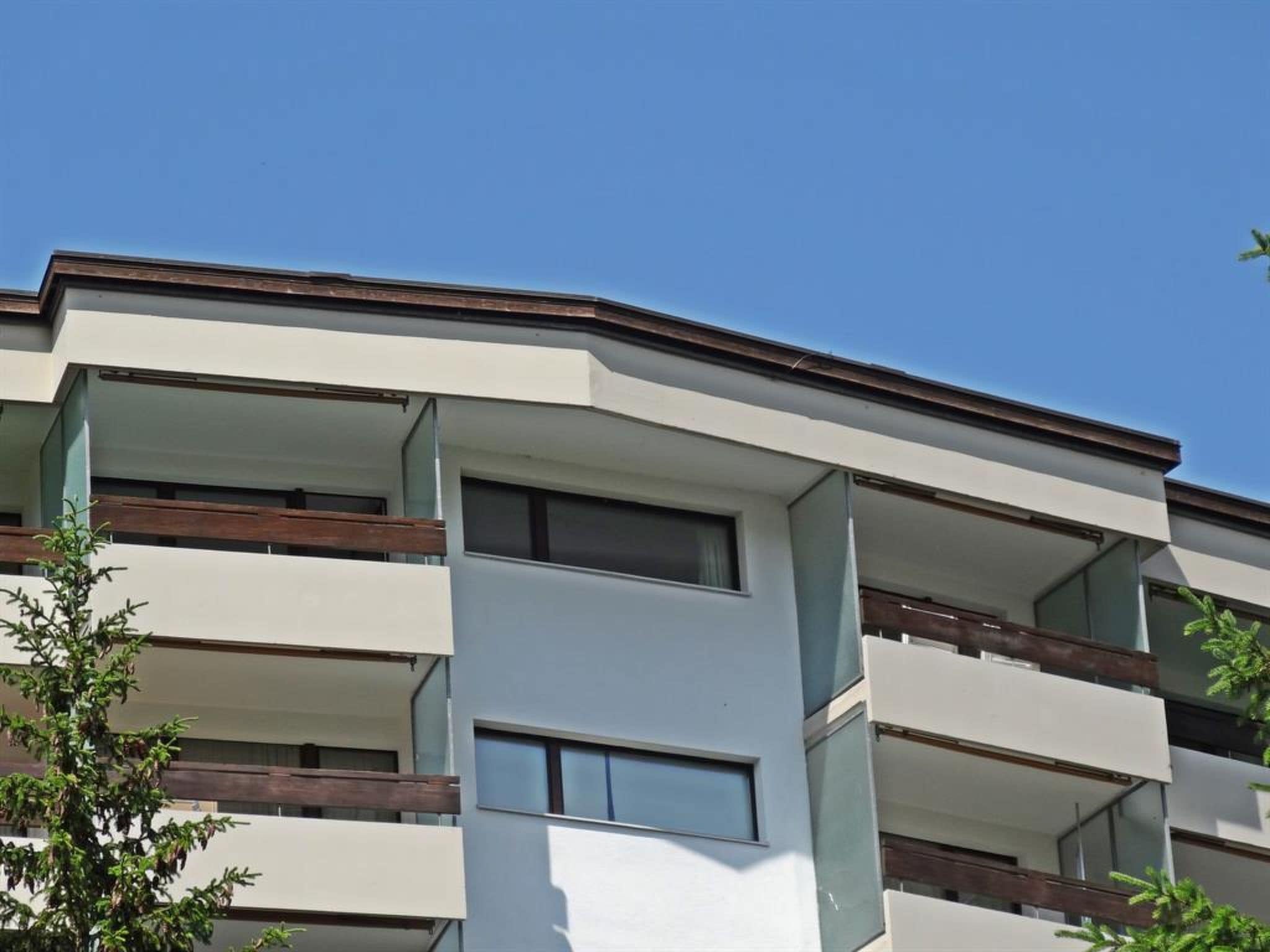 A multi-story building with balconies and large windows.