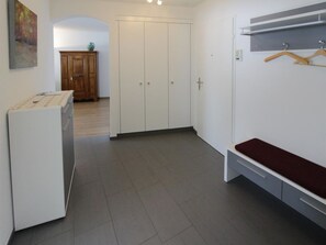 A room with a bed, a wardrobe, a bench, and a wall-mounted shelf. - Residenz im Park Whg Alpenblick Appartement/Fewo, Dusche oder Bad, WC by Interhome (Davos)
