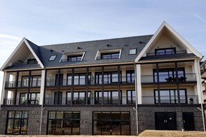 A multi-story building with balconies, large windows, and a modern architectural design. - Beach Residence A302 (Cadzand)
