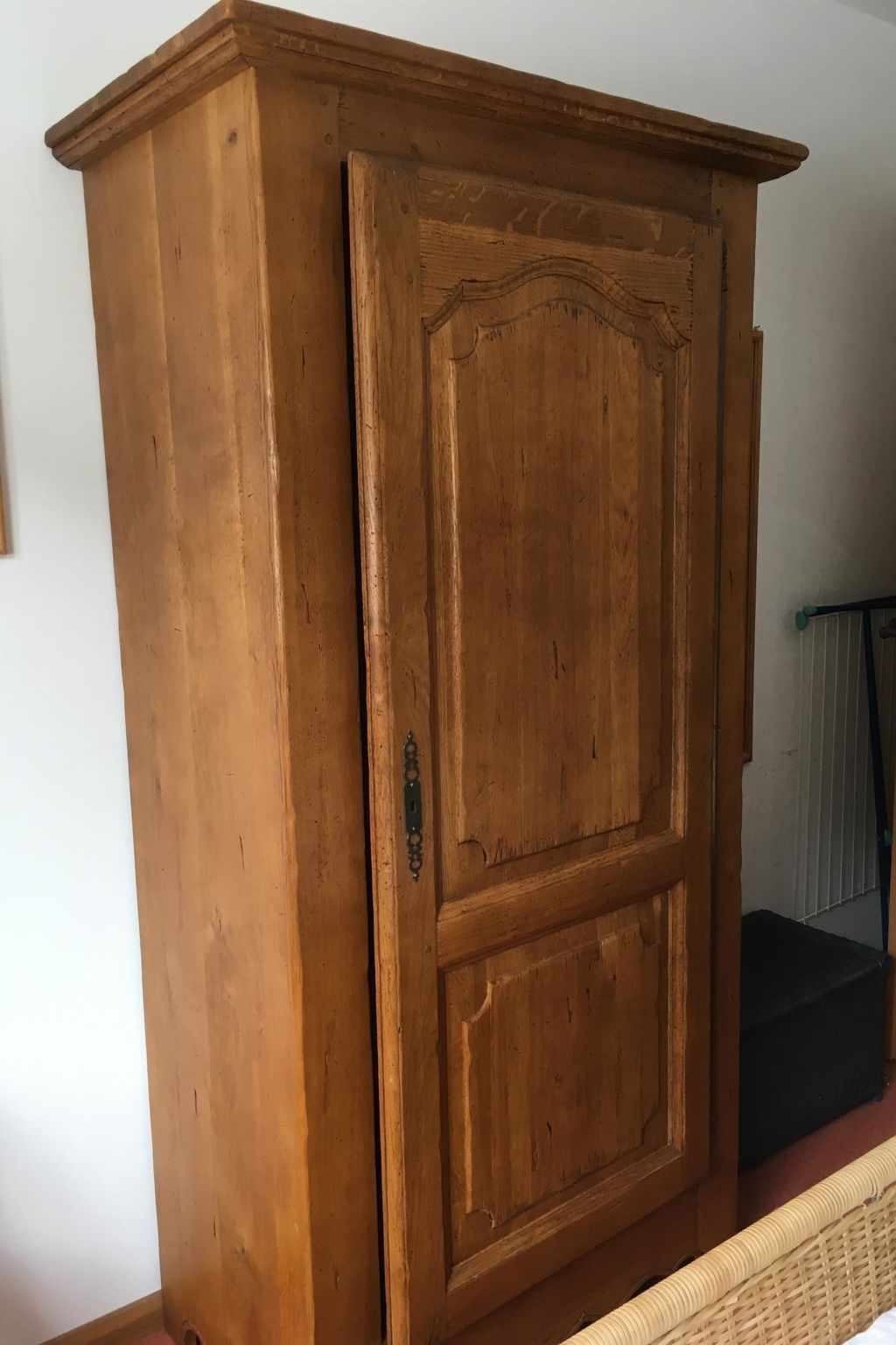 Ein Holzkleiderschrank mit Griff und Schloss.