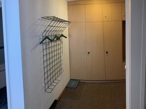 A hallway with a metal drying rack and a wooden wardrobe. - Sul Prau 9 Appartement/Fewo, Dusche oder Bad, WC 3½-Zimmerwohnung by Interhome (Klosters)