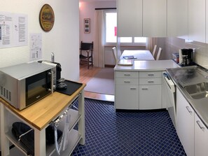 A compact kitchenette with a microwave, coffee maker, and a small oven. - Sul Prau 9 Appartement/Fewo, Dusche oder Bad, WC 3½-Zimmerwohnung by Interhome (Klosters)