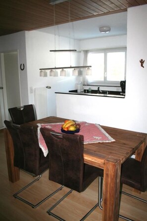 A dining area with a wooden table, chairs, and a fruit bowl. - Chesa Grischa 12 Appartement/Fewo, Dusche oder Bad, WC 3½-Zimmerwohnung by Interhome (Davos)