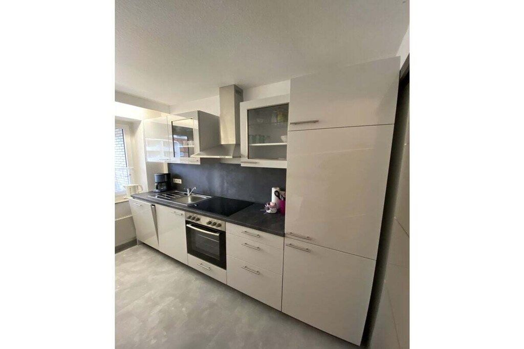 A modern kitchen with a built-in oven, a sink, and a stove.
