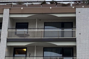 Ein mehrgeschossiges Gebäude mit Ziegelverkleidung, Balkonen und großen Fenstern.