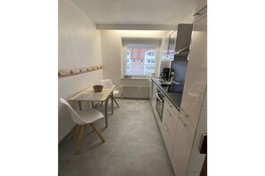 Eine kleine Küche mit Essbereich, ein Fenster mit Blick und ein Einbauofen.