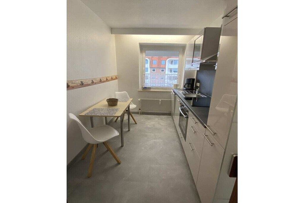 Eine kleine Küche mit Essbereich, ein Fenster mit Blick und ein Einbauofen.