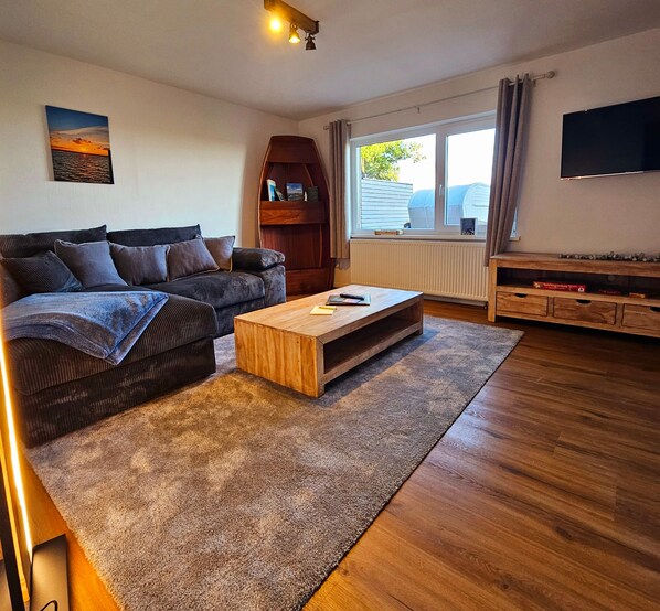 A living room with a sofa, coffee table, and a TV.