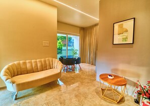 A modern living room with a sofa, a round table, and a coffee table. - Gems Munnar by VOYE HOMES (Devikolam)