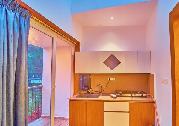 A compact kitchen with a gas stove, sink, and wooden cabinets.