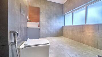 A modern bathroom with a shower, a toilet, and a sink.