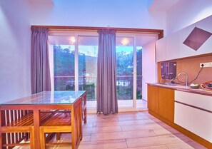 A modern kitchen with a wooden countertop and a built-in oven. - Gems Munnar by VOYE HOMES (Devikolam)
