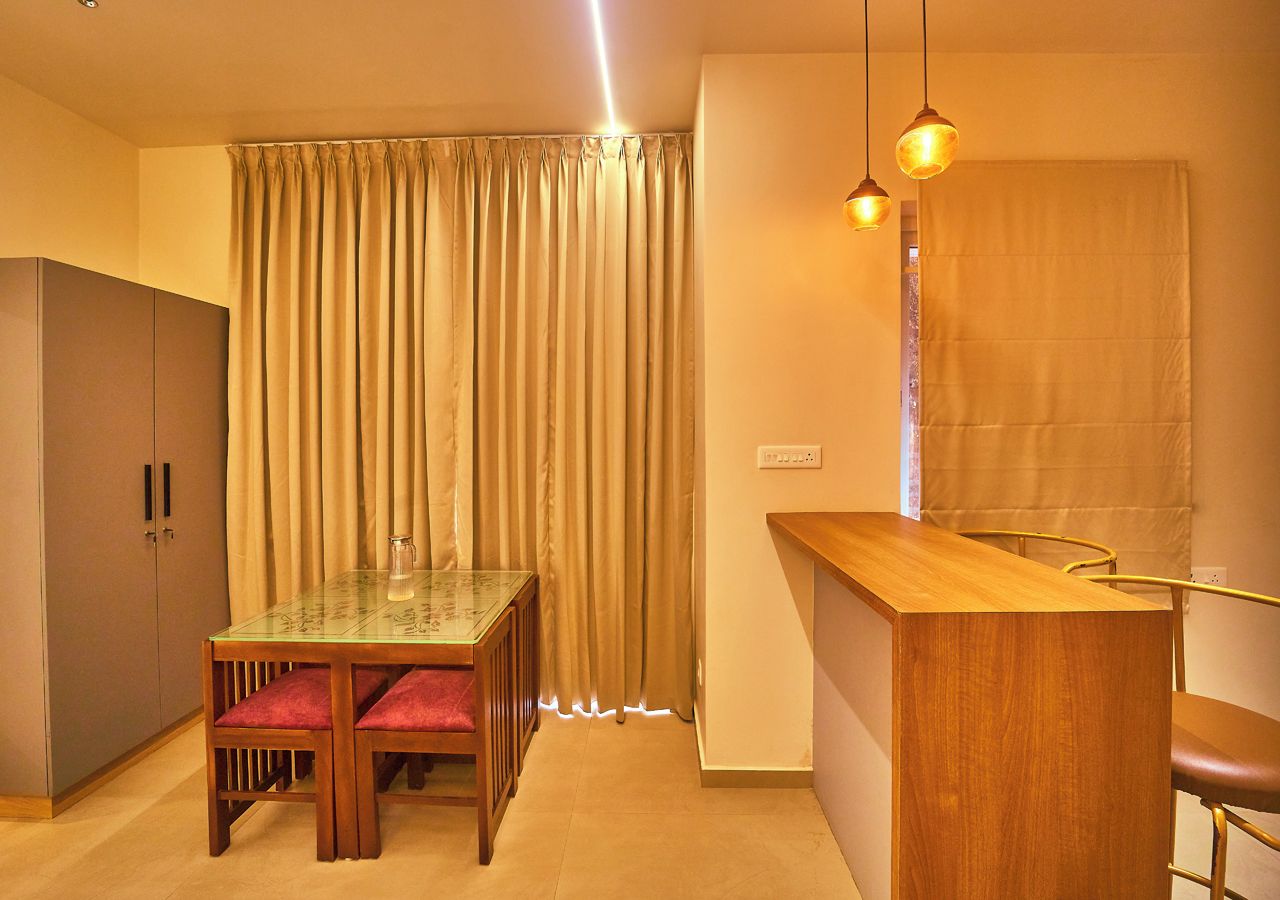 Un espacio habitable compacto con una mesa de comedor, sillas, kitchenette y un armario.