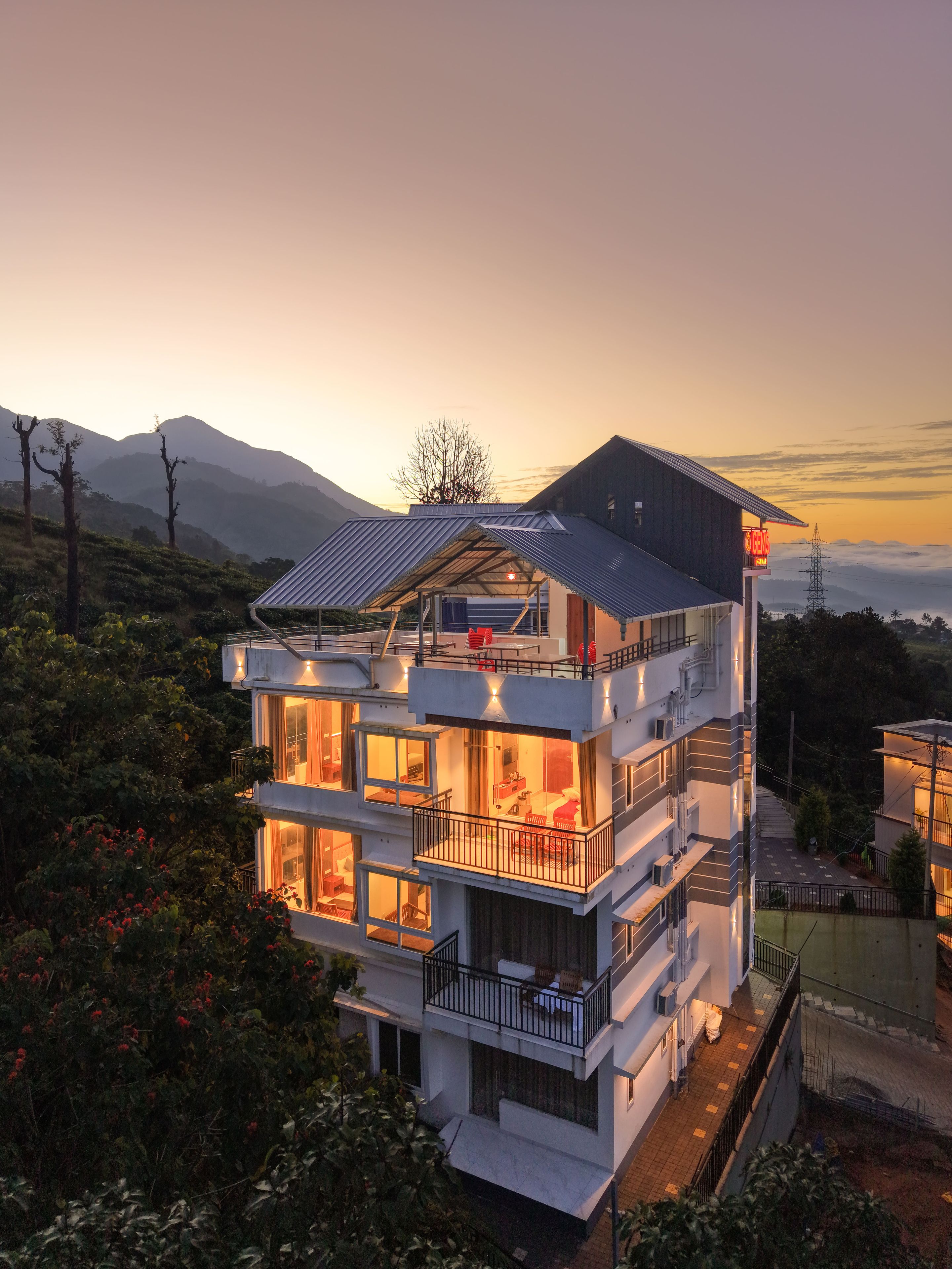 A multi-story hotel with balconies, large windows, and a view of the surrounding landscape.