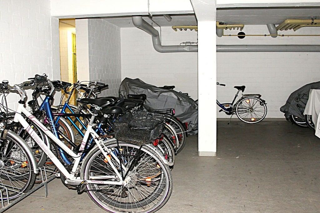 Un espace de stationnement pour vélos comprenant plusieurs vélos et un abri à vélos.