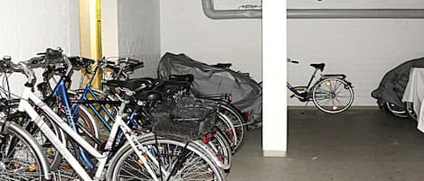 A bicycle parking area with multiple bicycles and a covered bike.