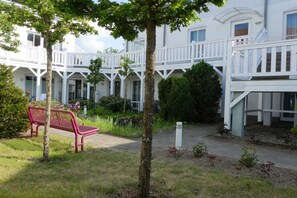 A building with multiple balconies and a central courtyard with a bench. - BOOTY 55, "Am Stadtwald", Apartment 9 (Kühlungsborn)