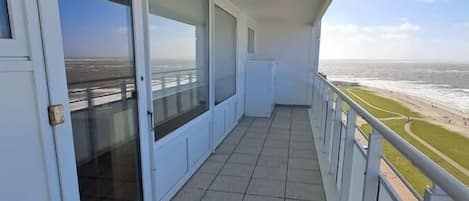Uma varanda com vista para o mar e uma ponte.