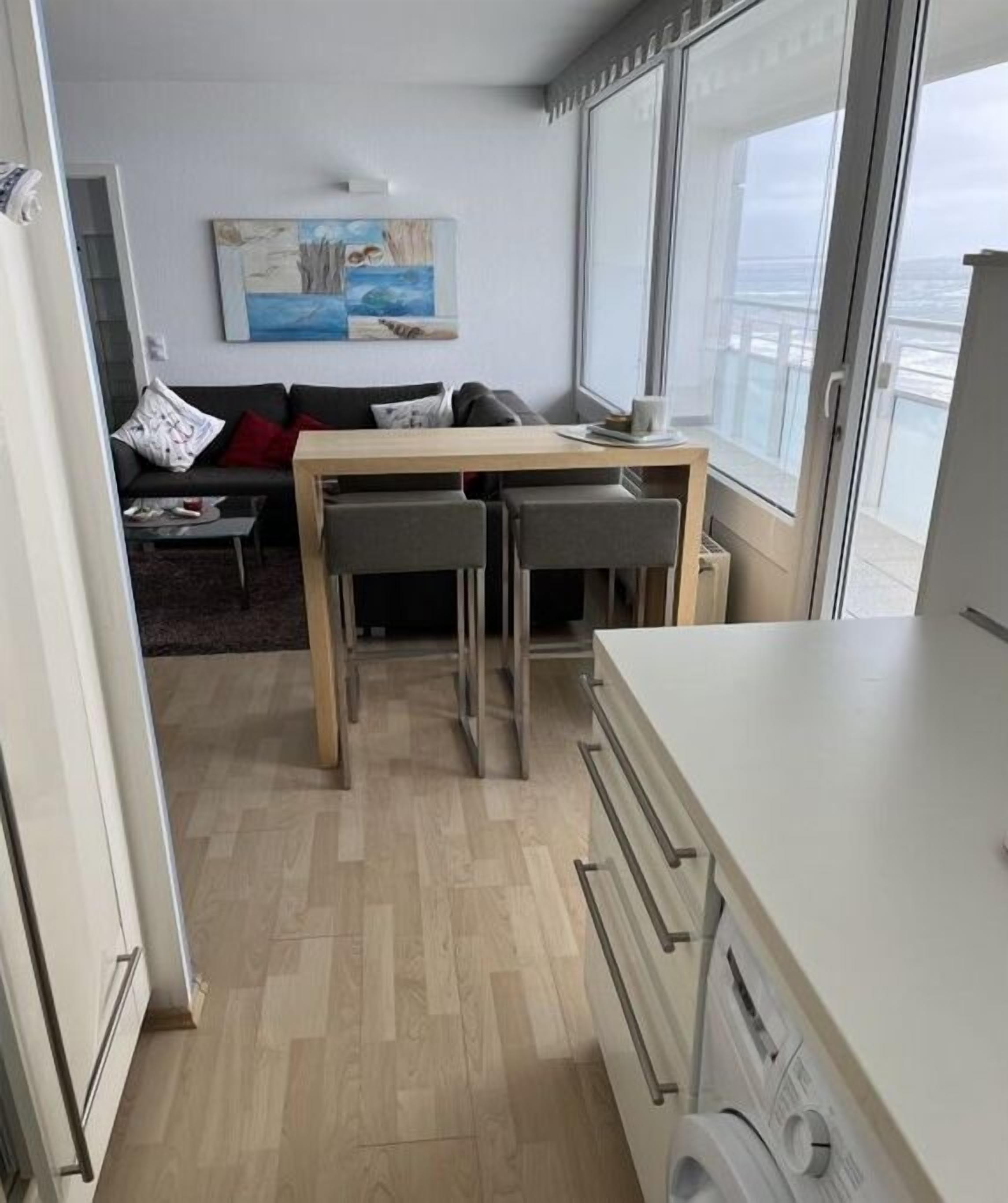 A compact living space with a kitchenette, a dining area, and a sofa.