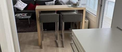A compact living space with a kitchenette, a dining area, and a sofa.