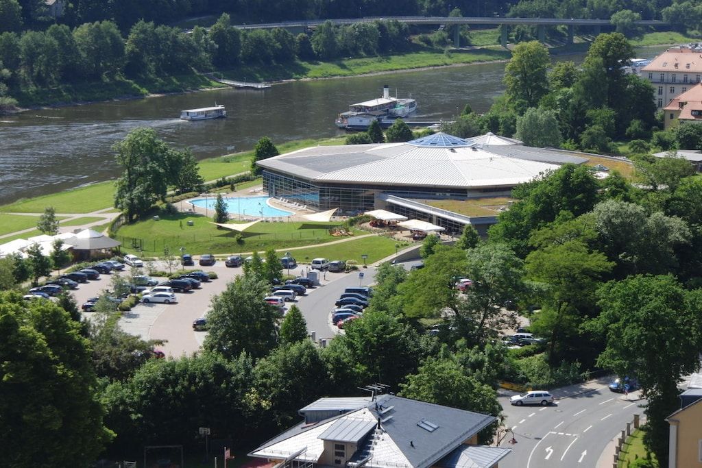 A large building with a circular central section and a swimming pool.