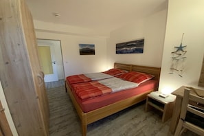 Ein Schlafzimmer mit einem hölzernen Bett, einem Nachttisch mit Lampe und einer Stern-Dekoration an der Wand.
