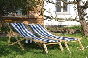 Two striped lounge chairs in a grassy area with a building in the background. - Ini's Kate West berth (Usedom)