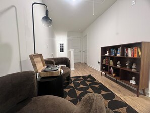 A living room with a record player, a bookshelf, and a patterned rug. - Hidden Atlanta Oasis (Atlanta)