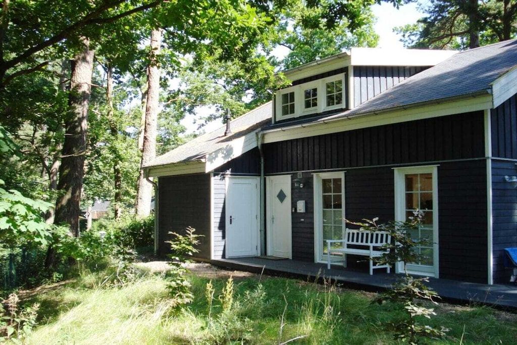 A two-story building with a porch and a bench.