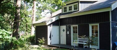 A two-story building with a porch and a bench.