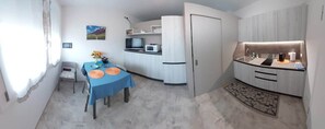 Eine kleine Küche mit Essbereich, einer Mikrowelle und einem Kühlschrank.