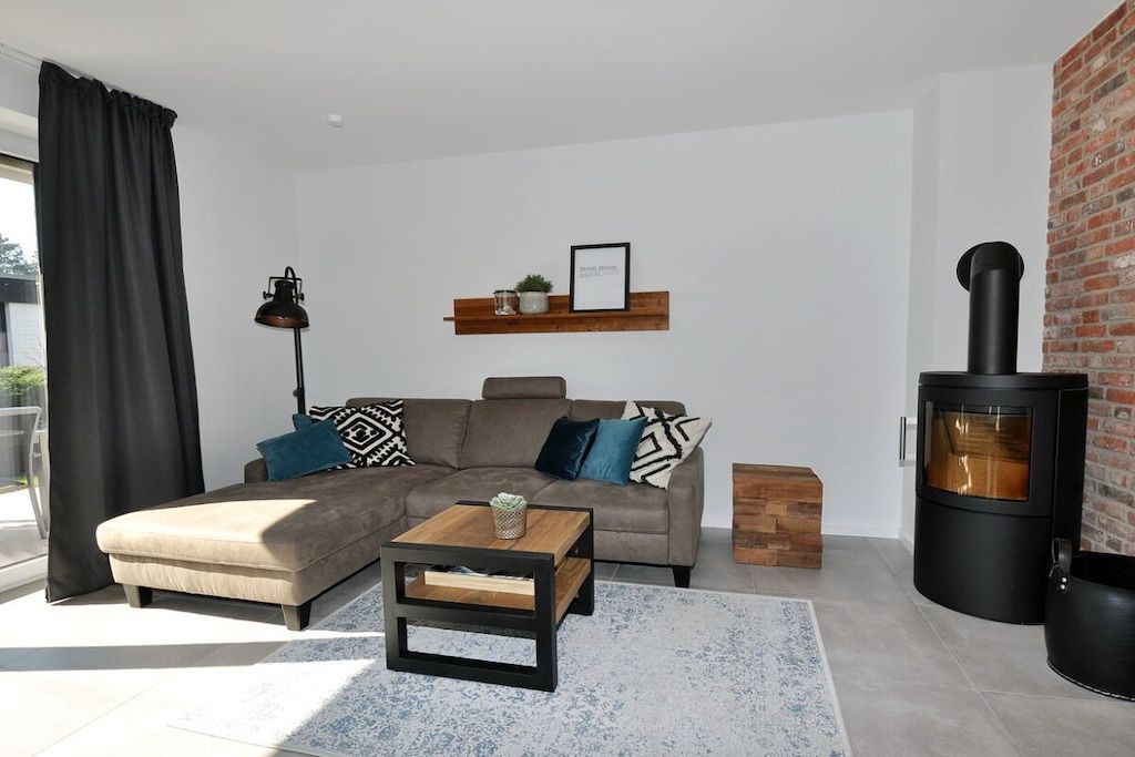 A modern living room with a sofa, coffee table, and a fireplace.