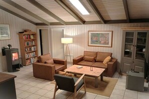 Ein gemütliches Wohnzimmer mit Kamin, Sofas, einem Couchtisch und einem Bücherregal.