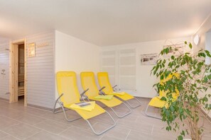 A room with three yellow chairs, a potted plant, and a wooden door. - Holiday home with 1 bedroom (Wieck\/Darß)