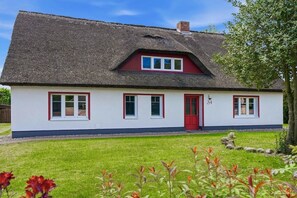 A single-story house with a thatched roof, white walls, and red trim. - Holiday home with 1 bedroom (Wieck\/Darß)